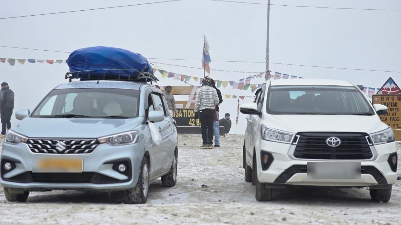 Dorjee Tours Innova and Ertiga fleet in the snow at Sela Pass