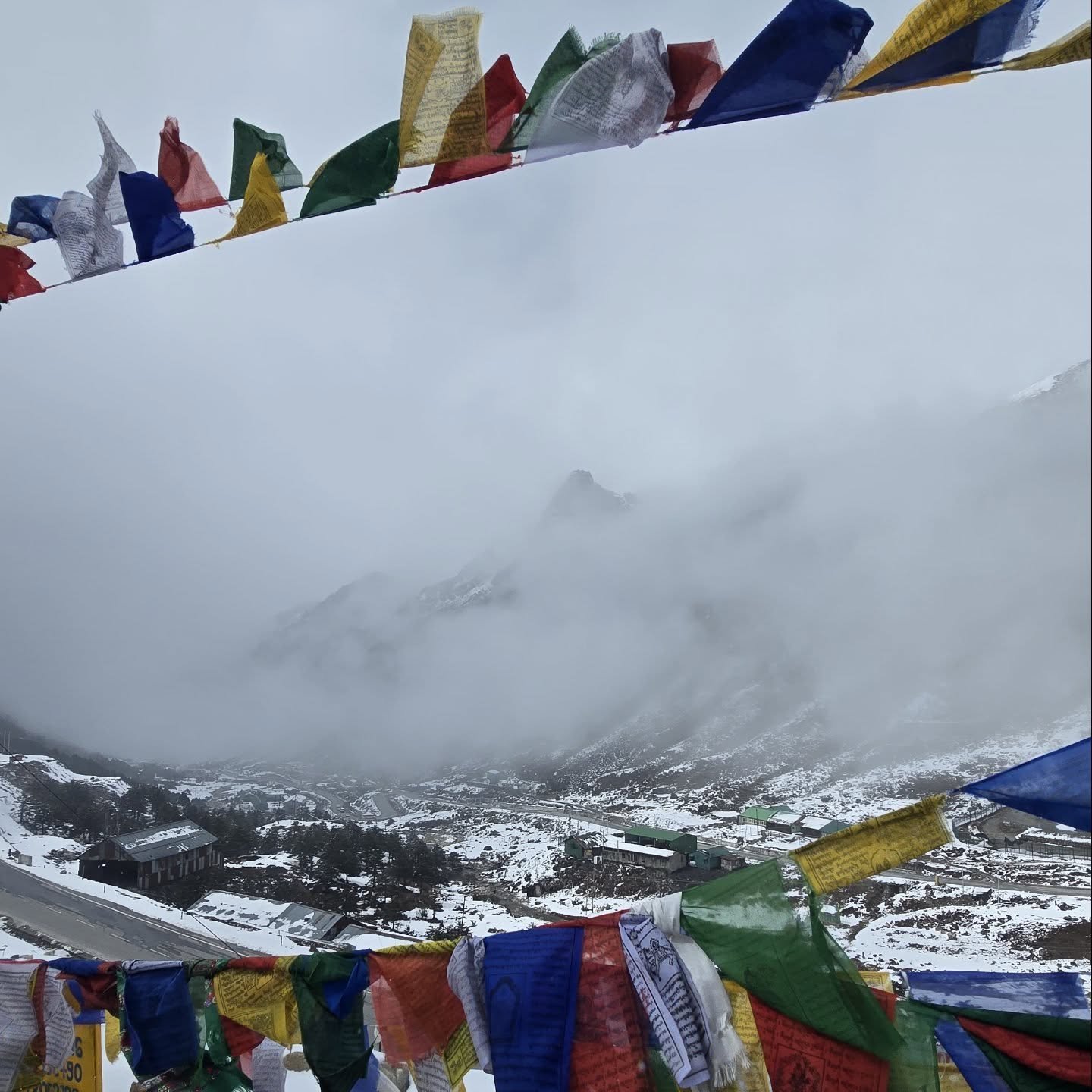 Snowy valley with prayer flags at Sela Pass